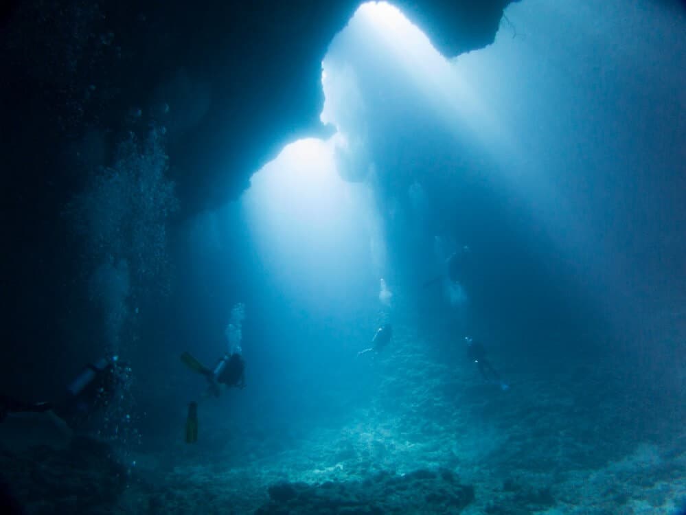 four schuba divers deep under water - in Palau