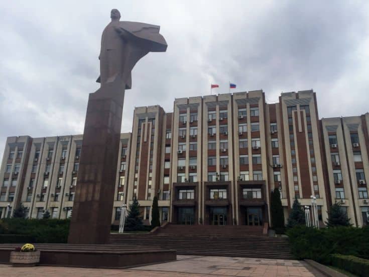 giant statue of Lenin in front of brick building