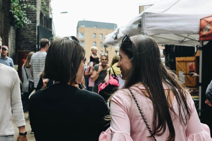 two women walking in a crowd