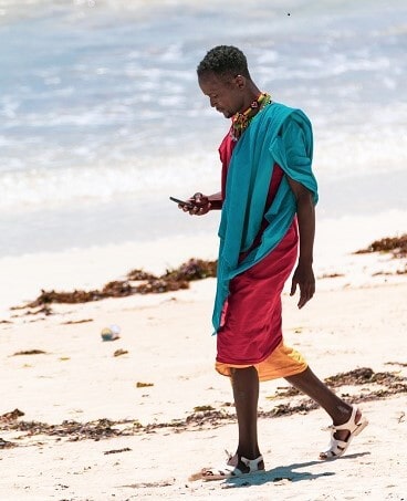 african man with cell phone - International Travel Packing List