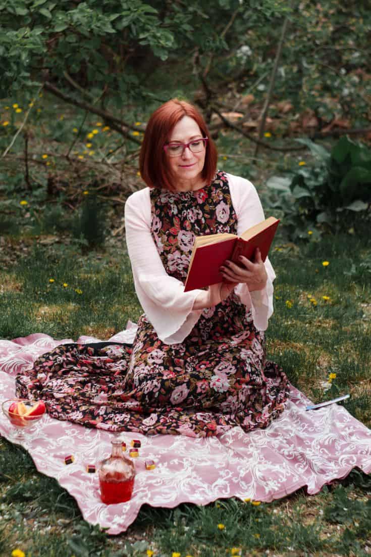 woman on a picnic blanket with a book