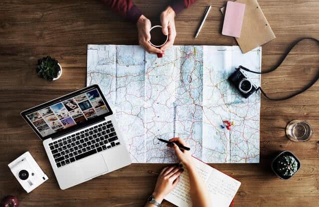 two people planning trip with a map and laptop - how to fly for free
