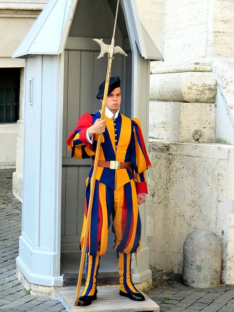 a swiss guard man in bright yellow blue and red outfit