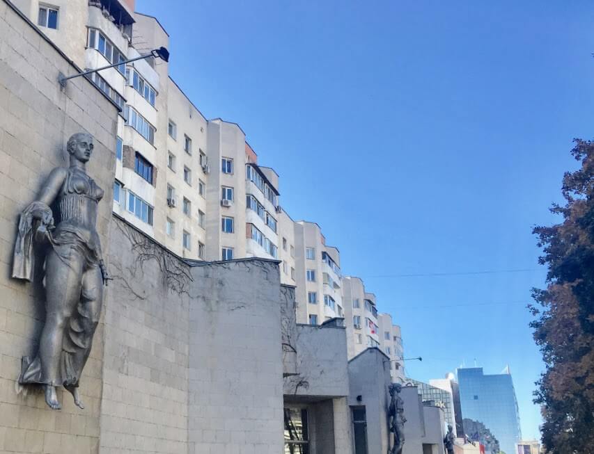 grey buildings with statue of woman