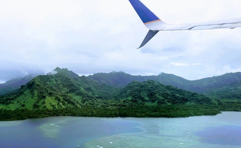 green hills of an island and wing of plane flying over Pohnpei