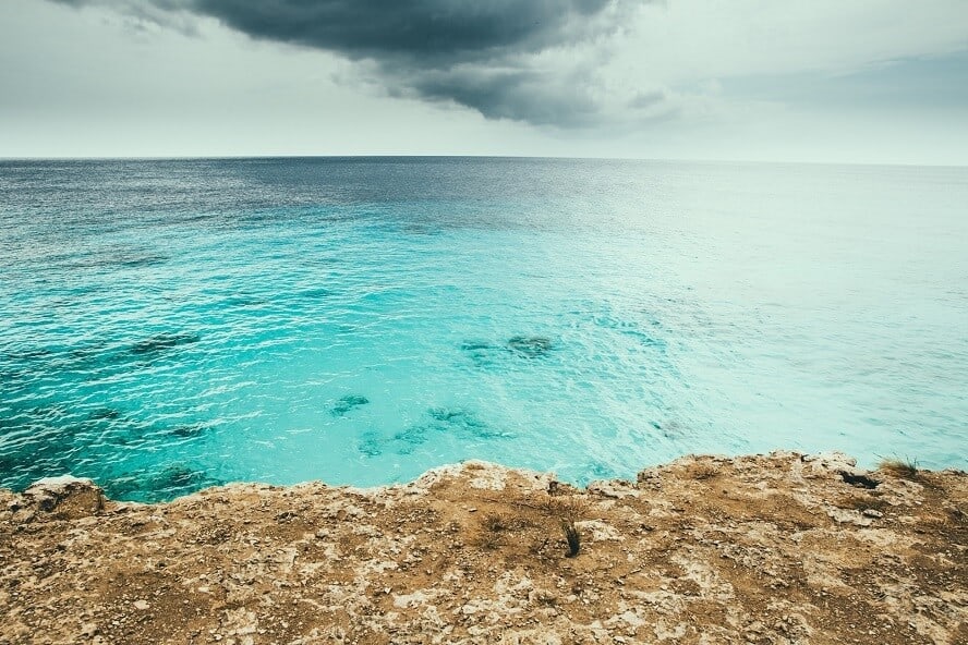 blue ocean seen from rocky shore 