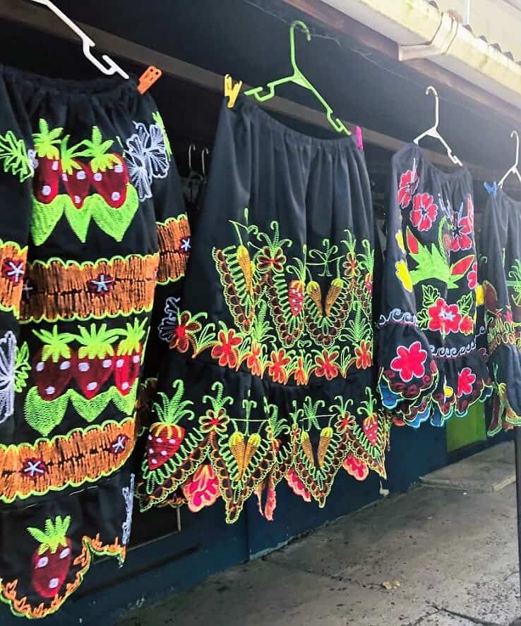 black and green Pohnpeian skirts on hangers in a market