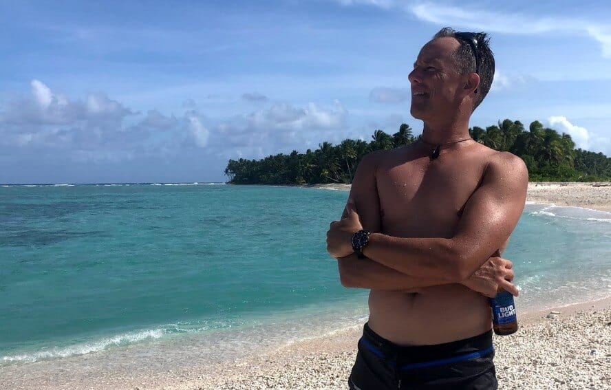 incredibly handsome shirtless man on beach holding bud lite bottle in marshall islands