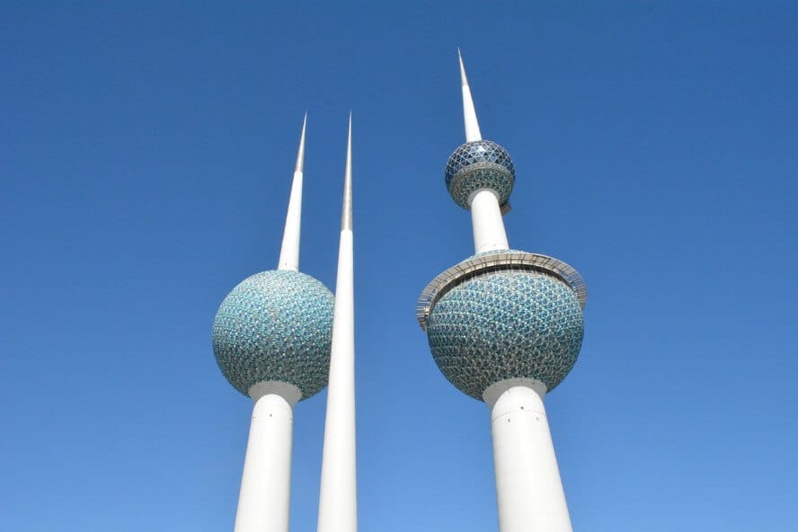 Kuwait Towers three white spires with green globes against a blue sky