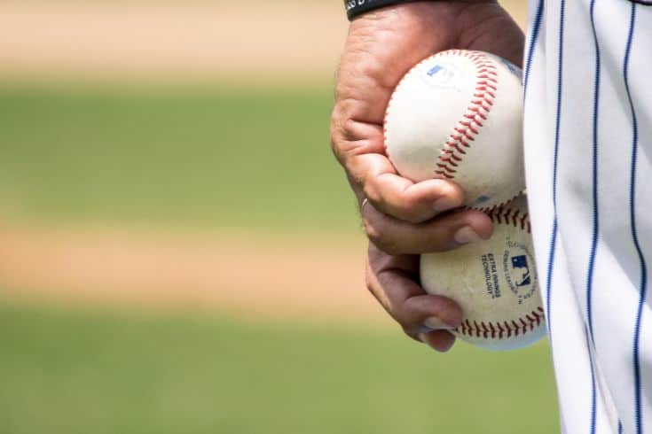 Dominican baseball player holding two baseballs