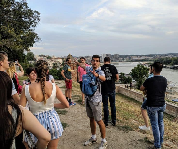 man pointing out things to do in Belgrade to group of people
