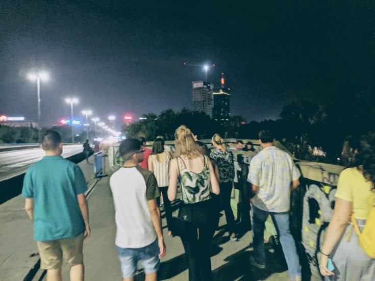 people walking on bridge at night
