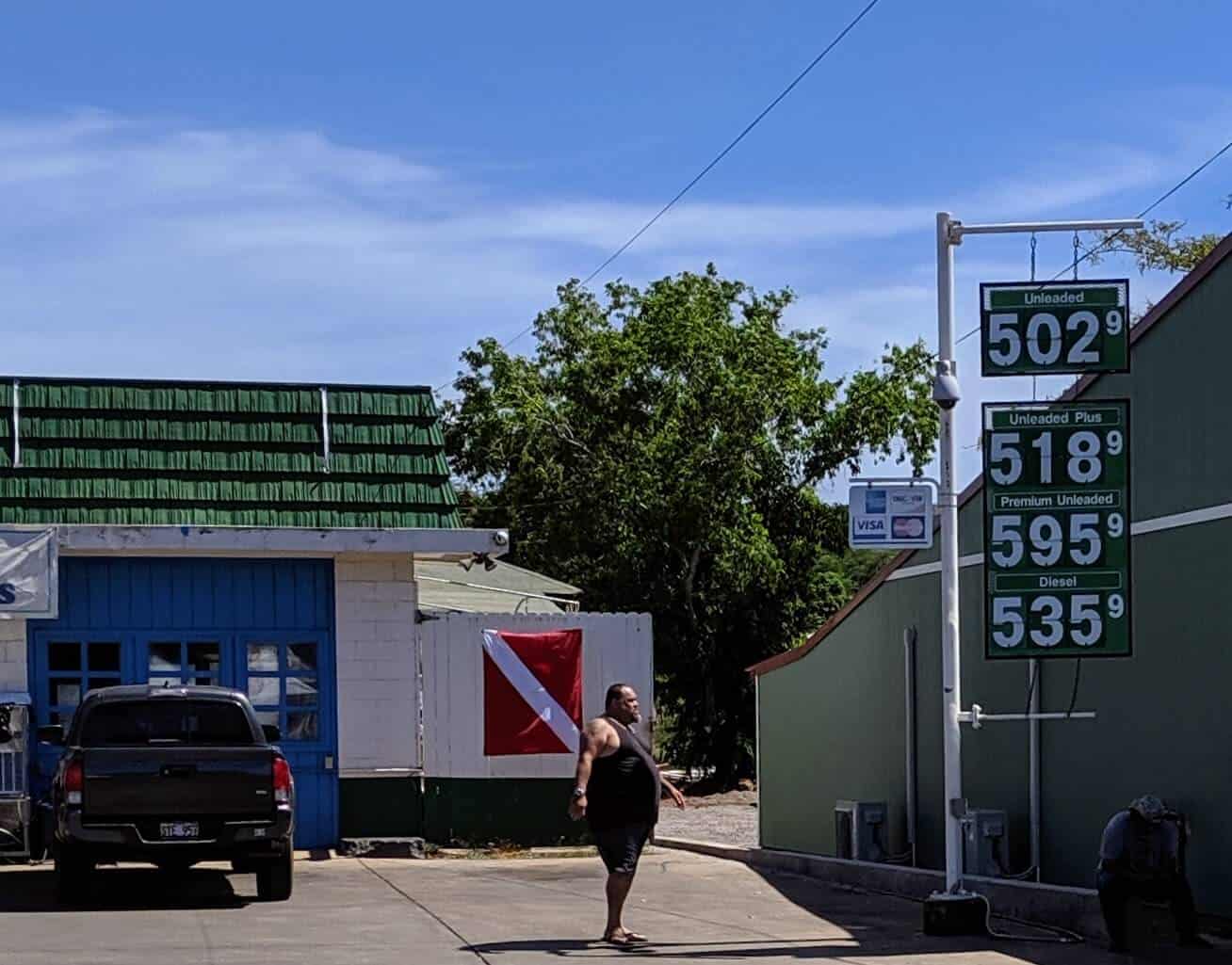man looking at sign with molokai gas prices