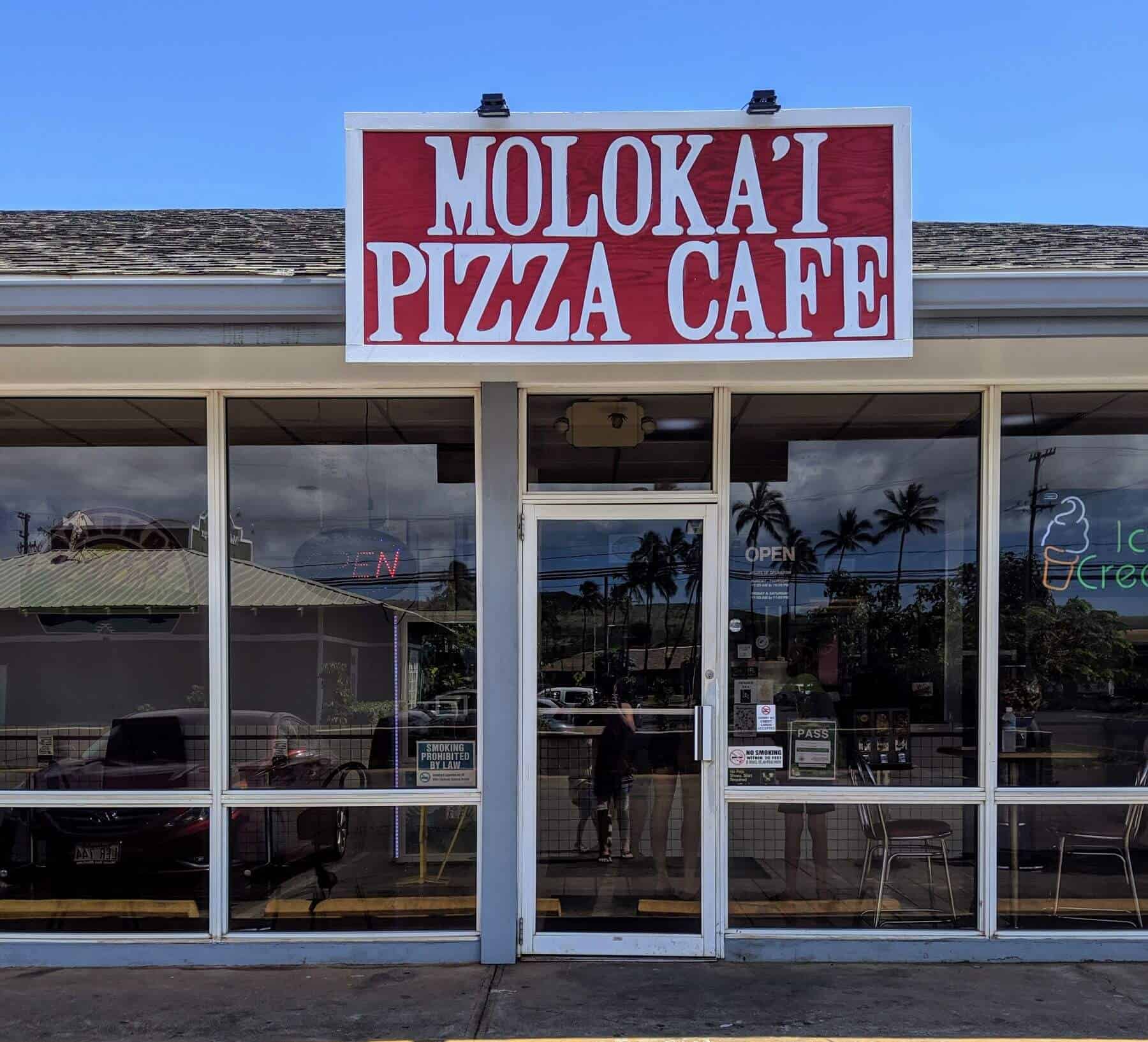 Molokai Pizza Café sign in front of glass building