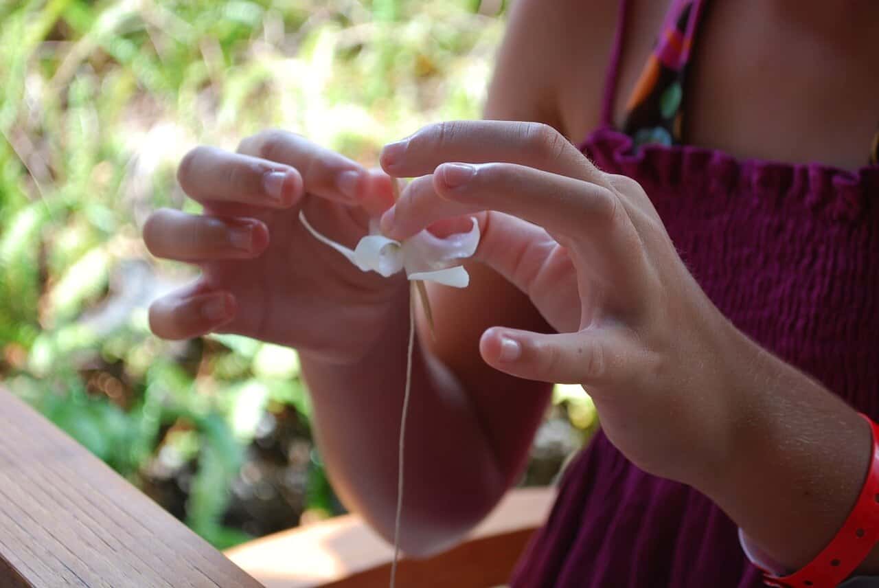 woman sewing Plumeria lei