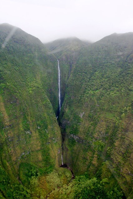 tall Moaula Falls in green valley