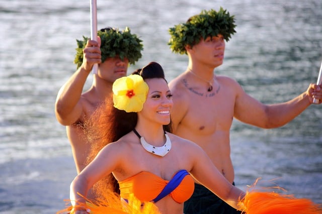 woman and two men performing at a luau