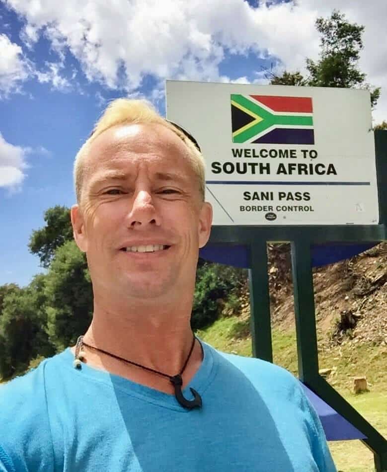 man next to sign for Sani Pass Tours stop at South Africa border control